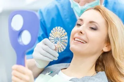 woman taking a look at the different shades of dental crowns prior to her procedure