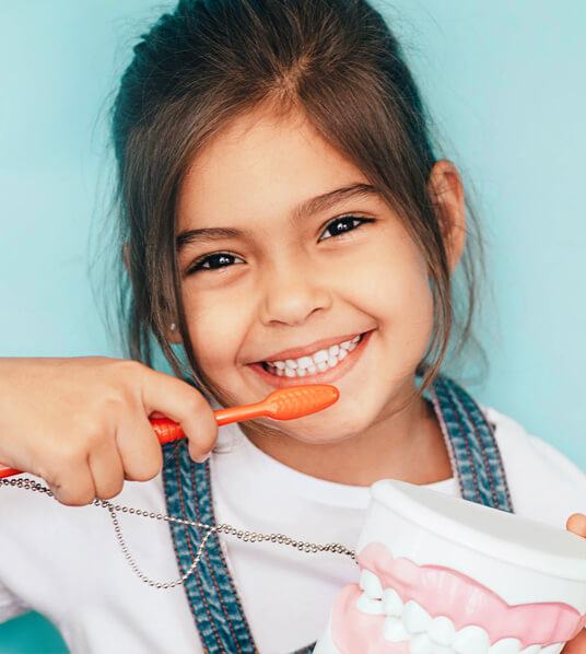image of smiling girl brushing teeth